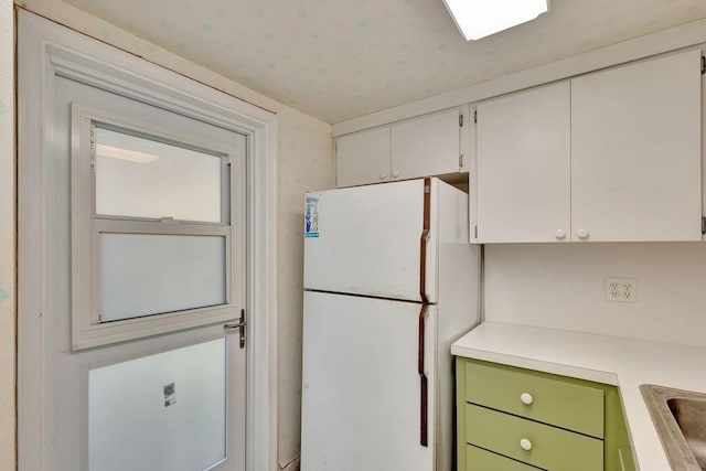 kitchen with white refrigerator, white cabinetry, and green cabinetry