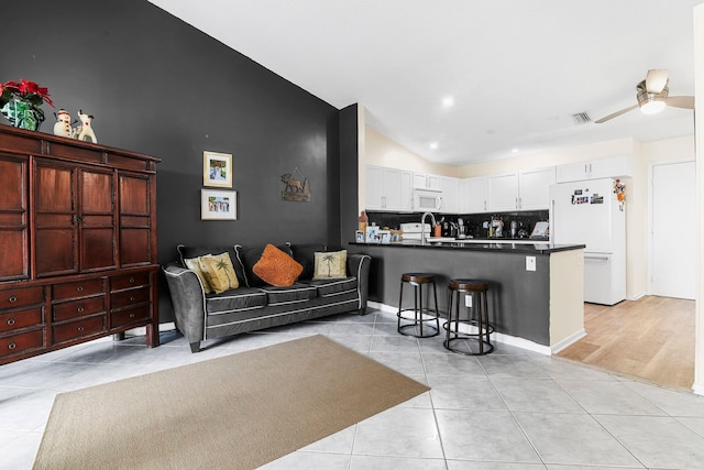 tiled living room featuring high vaulted ceiling and ceiling fan