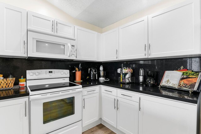 kitchen featuring white cabinets, sink, white dishwasher, and light hardwood / wood-style floors