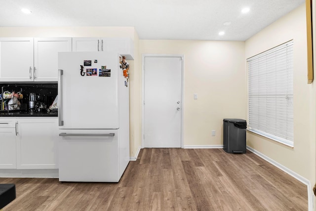 kitchen featuring white cabinets, light hardwood / wood-style floors, and white refrigerator