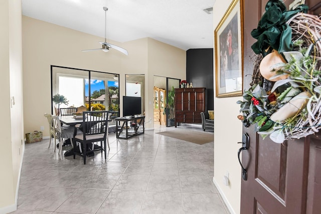 tiled dining area with high vaulted ceiling and ceiling fan