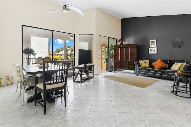 dining room featuring ceiling fan, high vaulted ceiling, and light tile patterned flooring