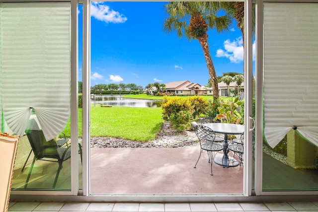 doorway to outside with light tile patterned flooring and a water view