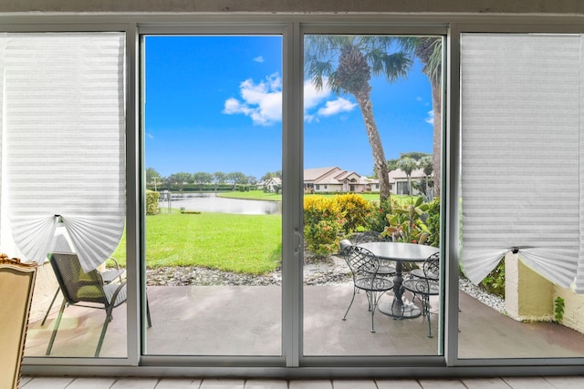 entryway with light tile patterned floors and a water view