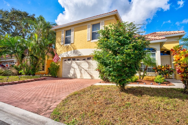 mediterranean / spanish home featuring a front lawn and a garage