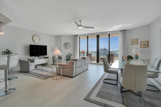 living room with ceiling fan, floor to ceiling windows, and light wood-type flooring