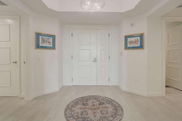 interior space featuring light wood-type flooring and an inviting chandelier