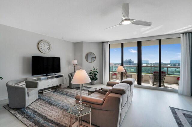 living room with light hardwood / wood-style flooring, floor to ceiling windows, and ceiling fan