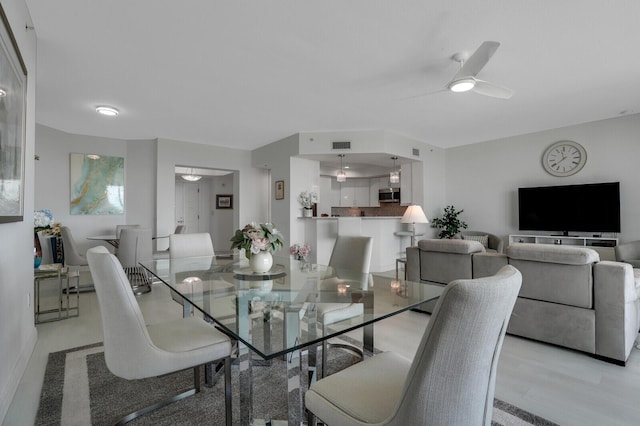 dining room with light hardwood / wood-style floors and ceiling fan