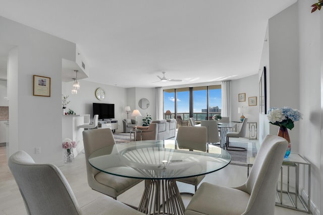 dining area with ceiling fan and expansive windows