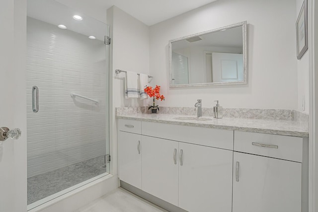 bathroom featuring vanity and a shower with door