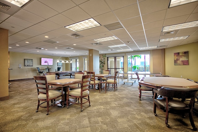 dining space with light carpet and a drop ceiling