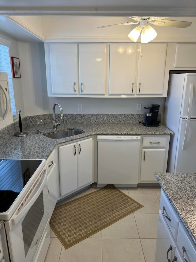 kitchen with white appliances, ceiling fan, sink, light tile patterned floors, and white cabinetry