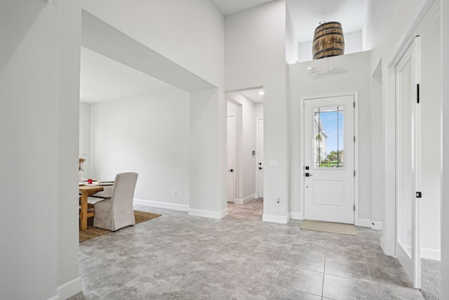 foyer with a towering ceiling and light tile patterned floors