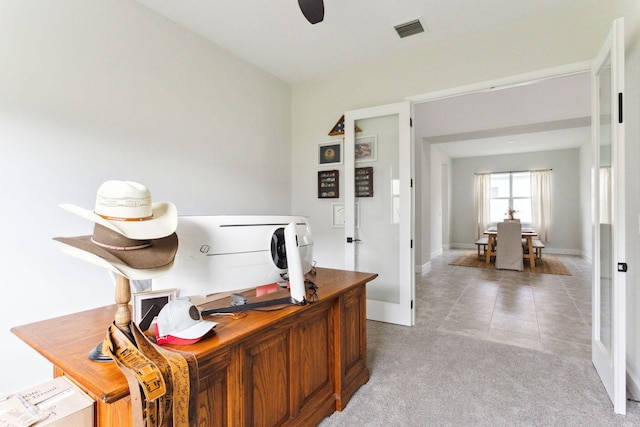 carpeted office space featuring ceiling fan