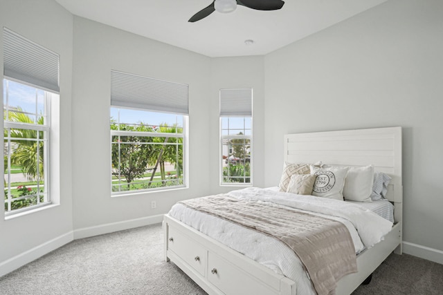 carpeted bedroom with multiple windows and ceiling fan