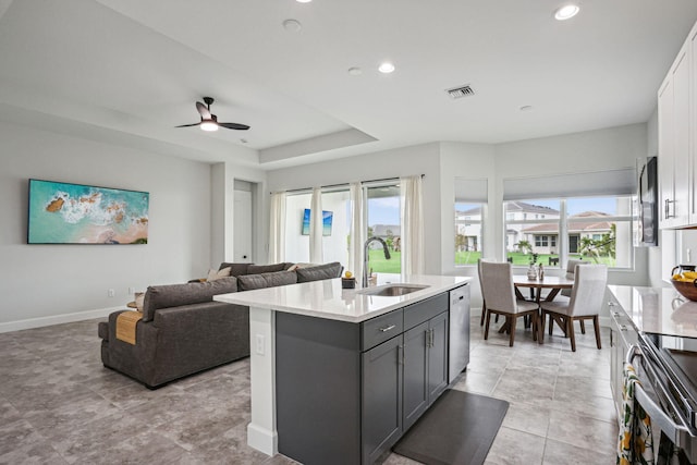 kitchen with white cabinetry, sink, an island with sink, and a healthy amount of sunlight