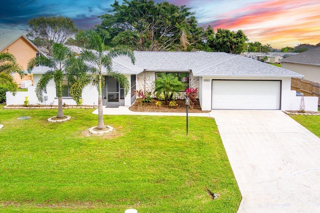 ranch-style home featuring a yard and a garage