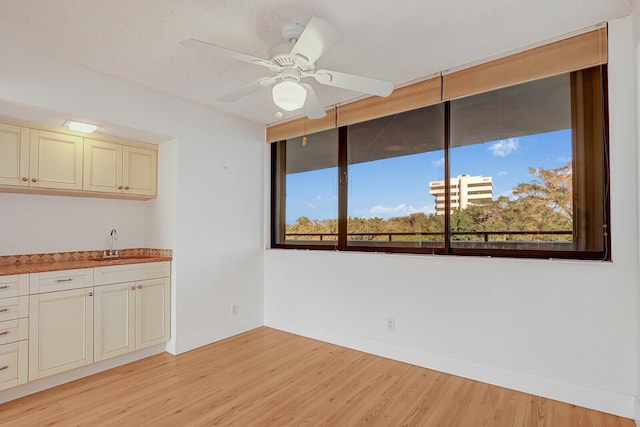 interior space with ceiling fan, light hardwood / wood-style floors, and sink