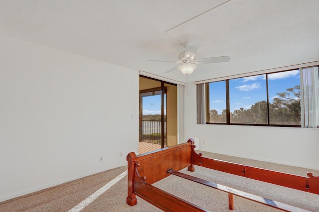 carpeted bedroom with multiple windows, ceiling fan, and a textured ceiling