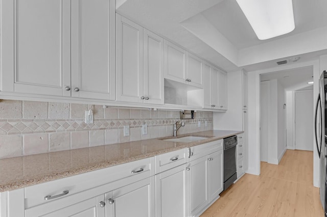 kitchen with dishwasher, backsplash, white cabinets, sink, and light hardwood / wood-style floors