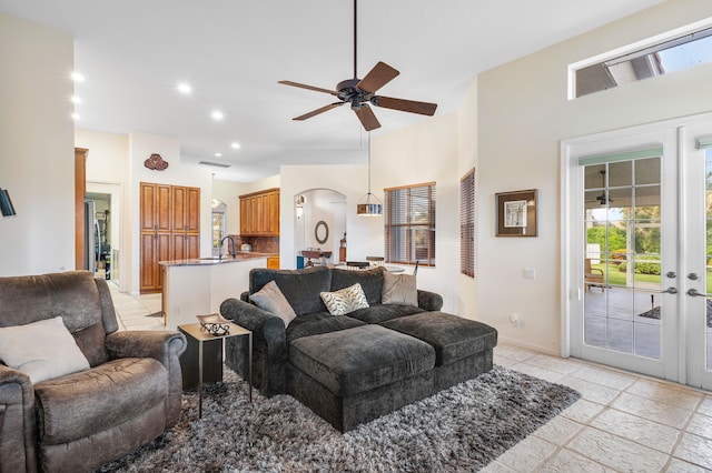 living room featuring french doors, a towering ceiling, and ceiling fan