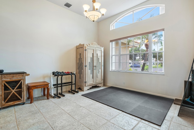 entryway featuring a high ceiling, plenty of natural light, and a notable chandelier