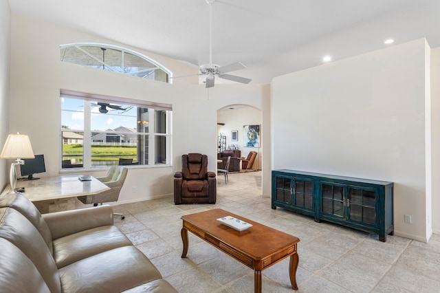 tiled living room with a high ceiling and ceiling fan