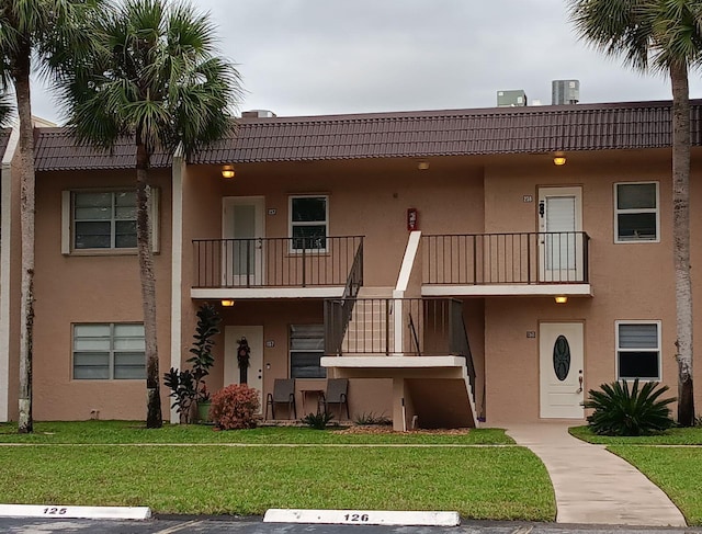 view of front of house with a front yard and central air condition unit