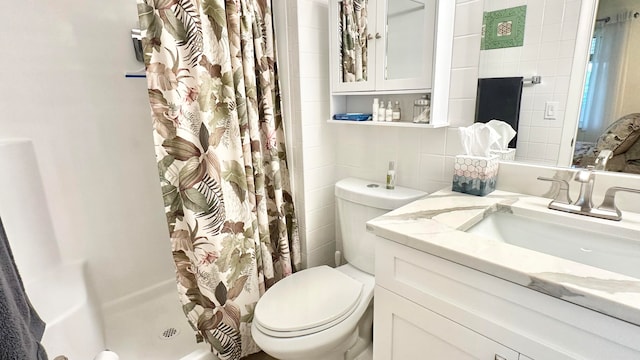 bathroom with vanity, curtained shower, toilet, and tile walls