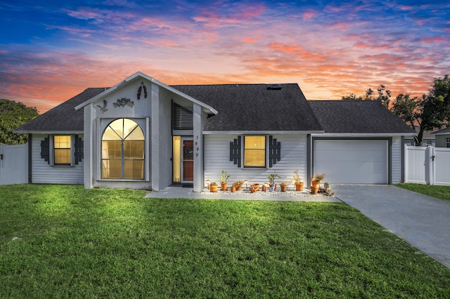 ranch-style house featuring a lawn and a garage