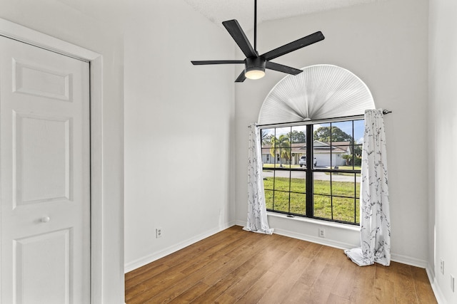 spare room with ceiling fan, light hardwood / wood-style floors, a textured ceiling, and vaulted ceiling