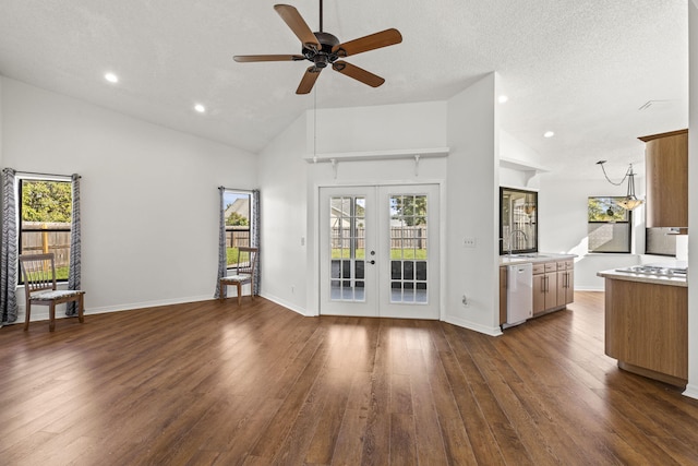 unfurnished living room featuring dark hardwood / wood-style flooring, french doors, high vaulted ceiling, and sink