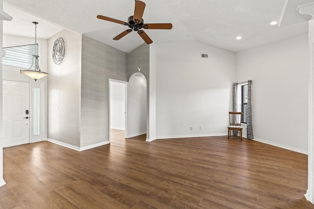 unfurnished living room with ceiling fan, dark hardwood / wood-style flooring, a textured ceiling, and high vaulted ceiling