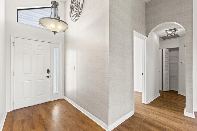 foyer with hardwood / wood-style floors and a towering ceiling