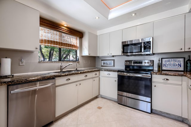 kitchen featuring appliances with stainless steel finishes, white cabinetry, ornamental molding, and sink