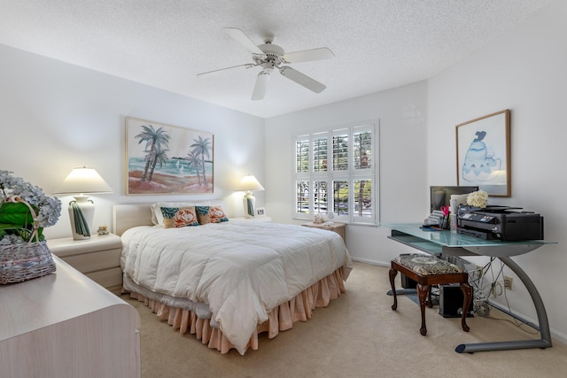 bedroom featuring a textured ceiling, light colored carpet, and ceiling fan