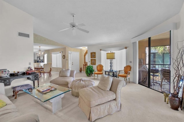 carpeted living room with ceiling fan with notable chandelier and lofted ceiling