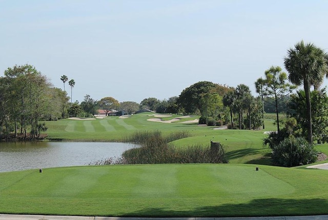 surrounding community featuring a lawn and a water view