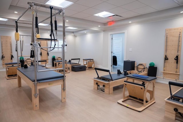 exercise area with a drop ceiling and light hardwood / wood-style flooring