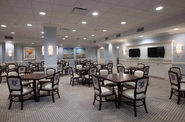 dining area with crown molding and light colored carpet