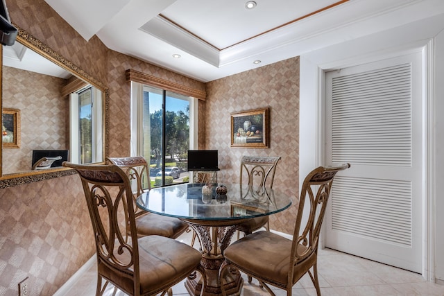 tiled dining room featuring a raised ceiling and crown molding