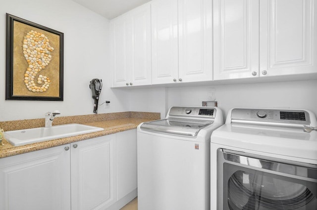 laundry room with cabinets, sink, and washing machine and clothes dryer