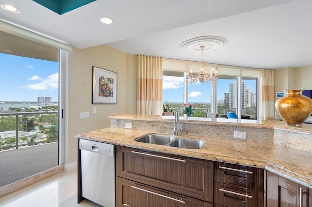 kitchen with light stone countertops, dishwasher, sink, hanging light fixtures, and an inviting chandelier