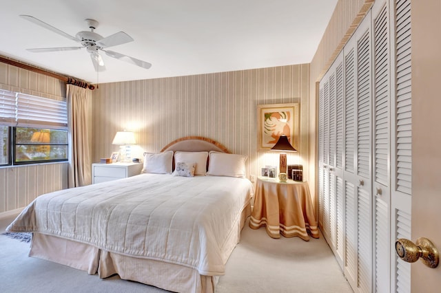 carpeted bedroom featuring ceiling fan and a closet