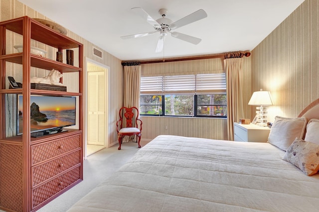 bedroom with ceiling fan, light carpet, and a closet