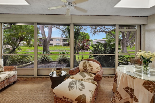 sunroom / solarium with a skylight and ceiling fan