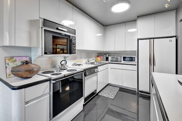 kitchen featuring white cabinets, white appliances, tile patterned floors, and sink