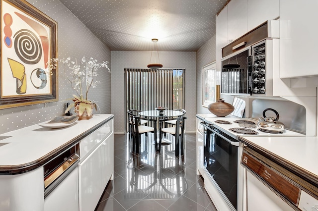 kitchen with decorative light fixtures, white cabinetry, dark tile patterned floors, and white electric stove