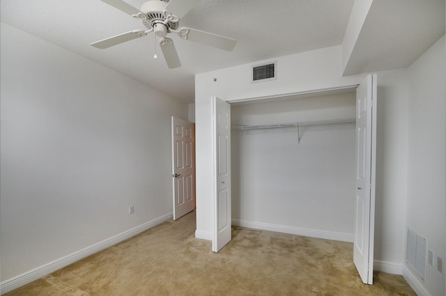 unfurnished bedroom with ceiling fan, light colored carpet, and a closet